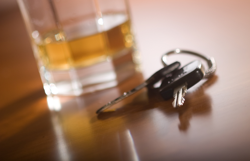 two car keys sitting next to an alcoholic drink