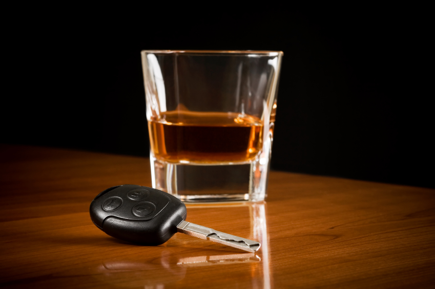 car key fob laying next to a shot glass of whiskey