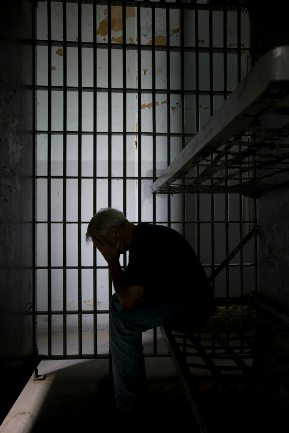 inmate sitting in a prison cell