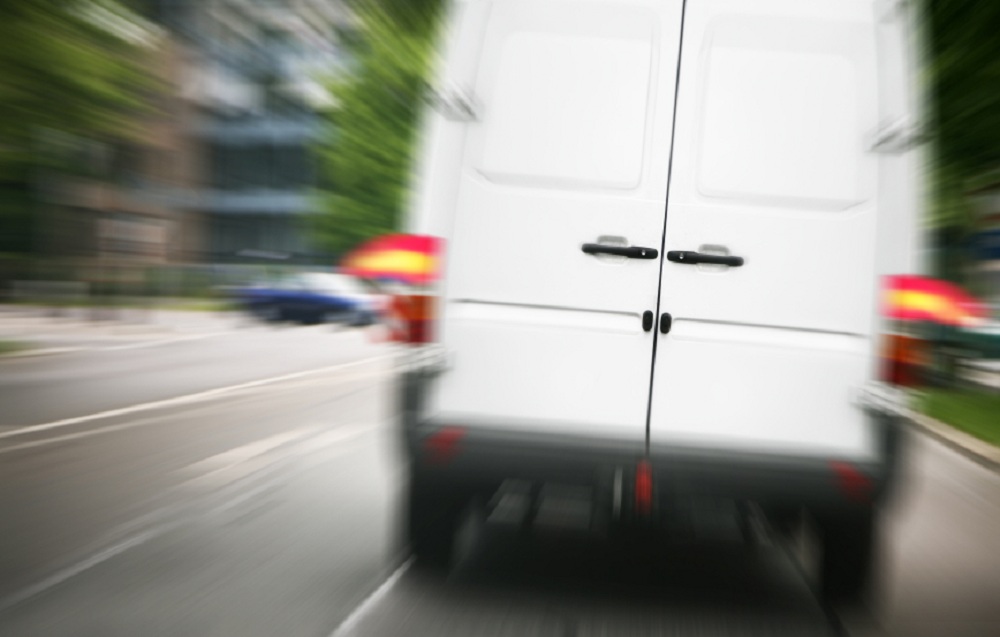 white delivery van speeding down the roadway