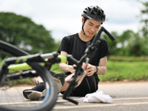 A Young man on the street in pain after falling off his bike