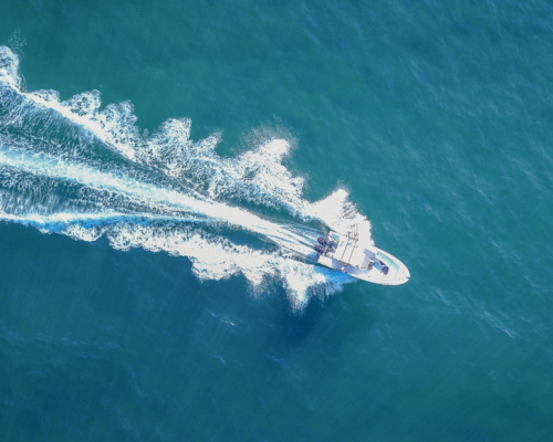 A boat from a birds eye view going through the water.